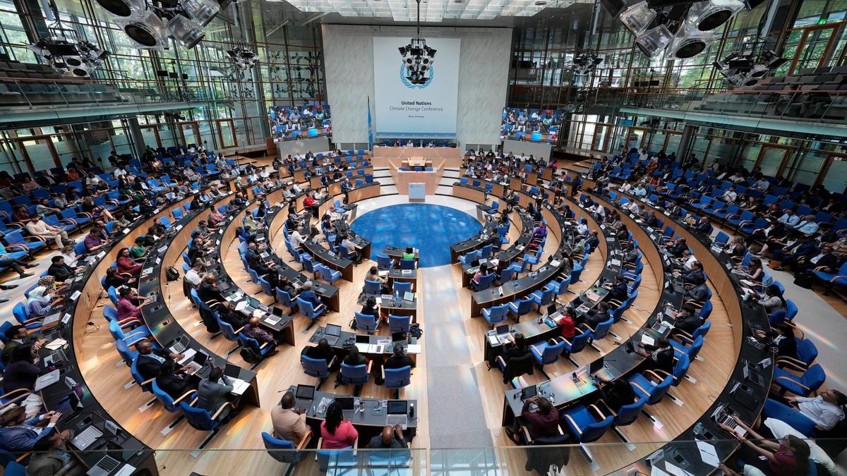 An overhead shot of the climate conference in Bonn last June. Desks are arranged in a circle in a high-ceilinged conference r