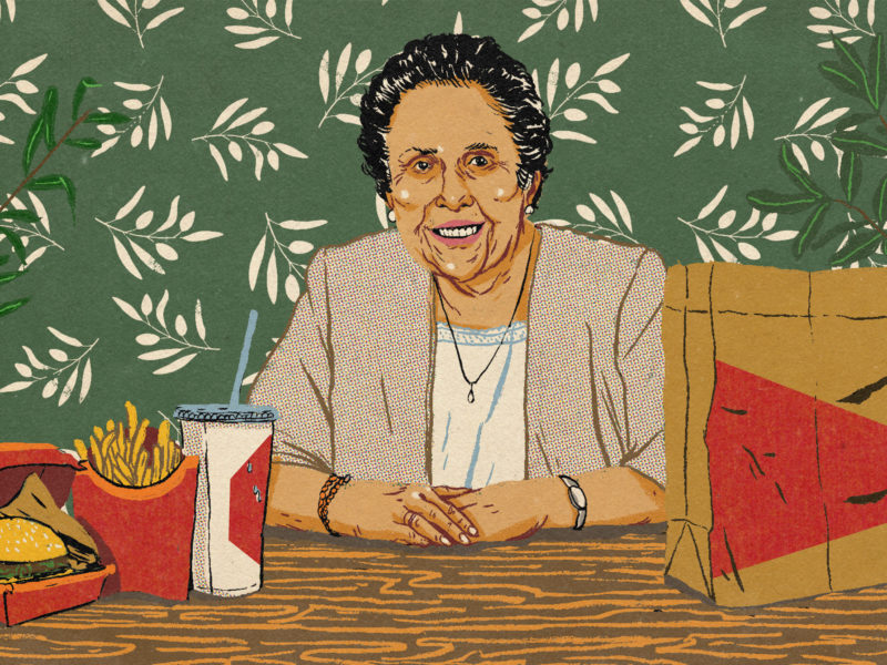 An illustration of Aban Pestonjee sitting at a table with a fast food meal.