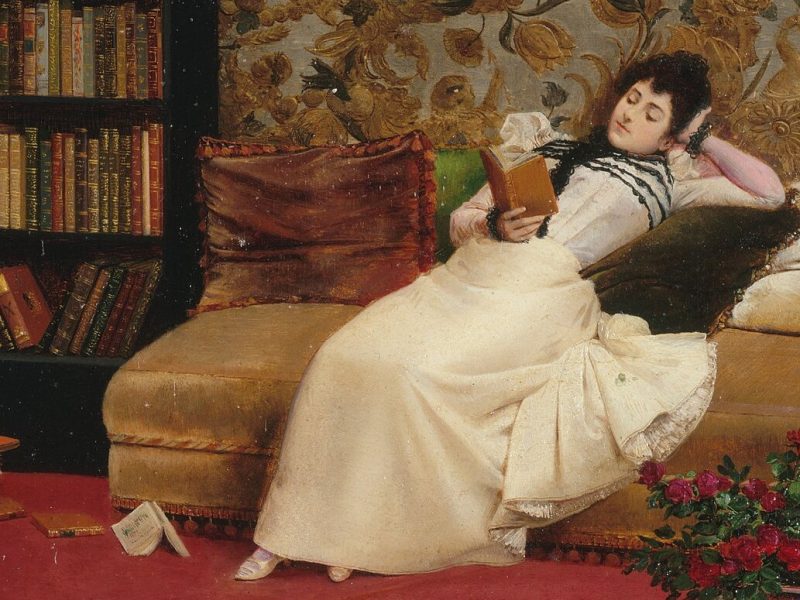 The oil painting "Reading" by Georges Croegaert, depicting a woman lying back on a couch and reading a book.