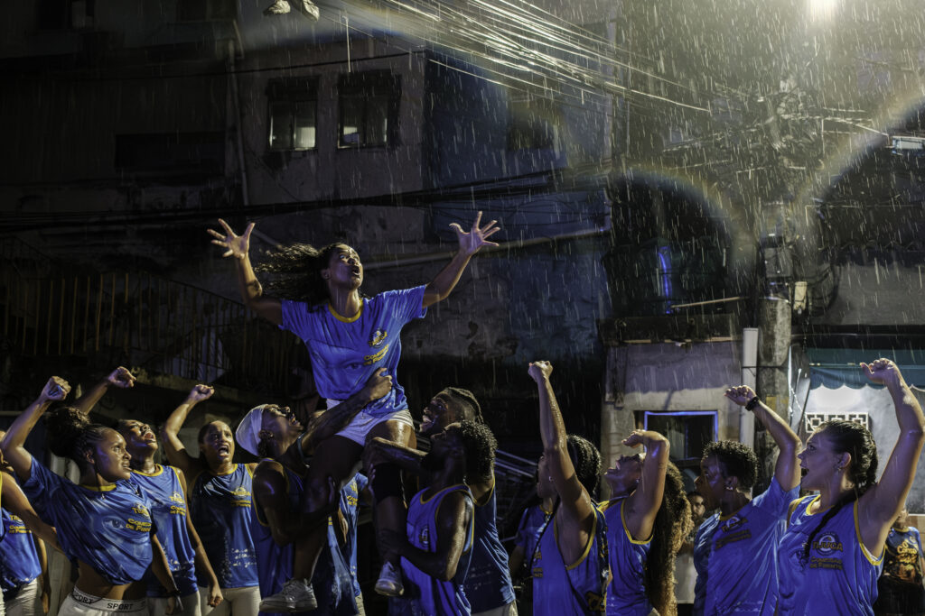During a street rehearsal by the Unidos da Tijuca samba school, and under heavy rain, the opening performance group performs one of its choreographies from the storyline honoring writer Carolina Maria de Jesus near Favela do Borel, in the Tijuca neighborhood of Rio de Janeiro, Brazil.