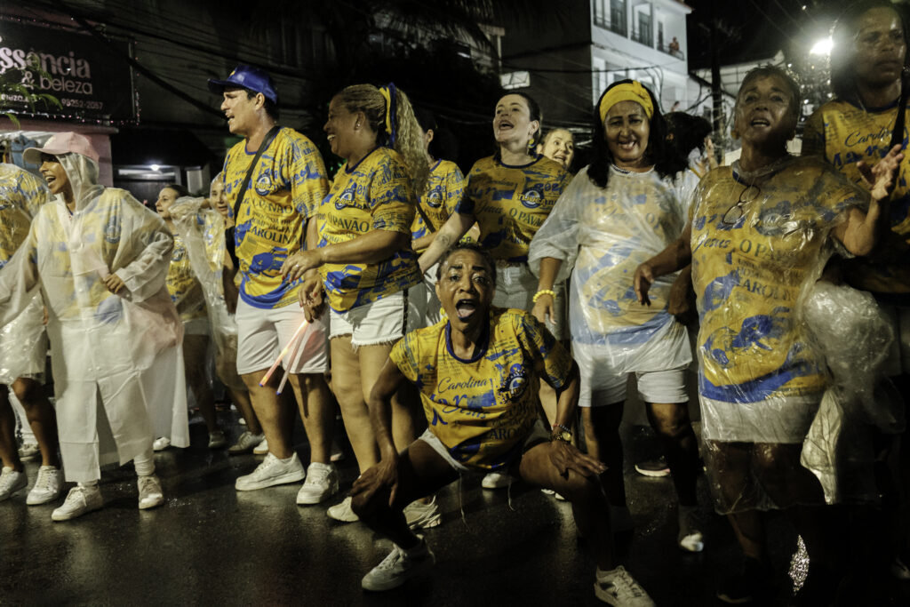 Under heavy rain, members of one of the wings of the Unidos da Tijuca samba school parade through the neighborhood streets near Favela do Borel during the final rehearsal before Carnival in the city of Rio de Janeiro, Brazil.