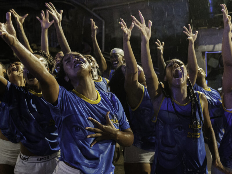 During a street rehearsal by the Unidos da Tijuca samba school, and under heavy rain, the opening performance group performs one of its choreographies from the storyline honoring writer Carolina Maria de Jesus near Favela do Borel, in the Tijuca neighborhood of Rio de Janeiro, Brazil.