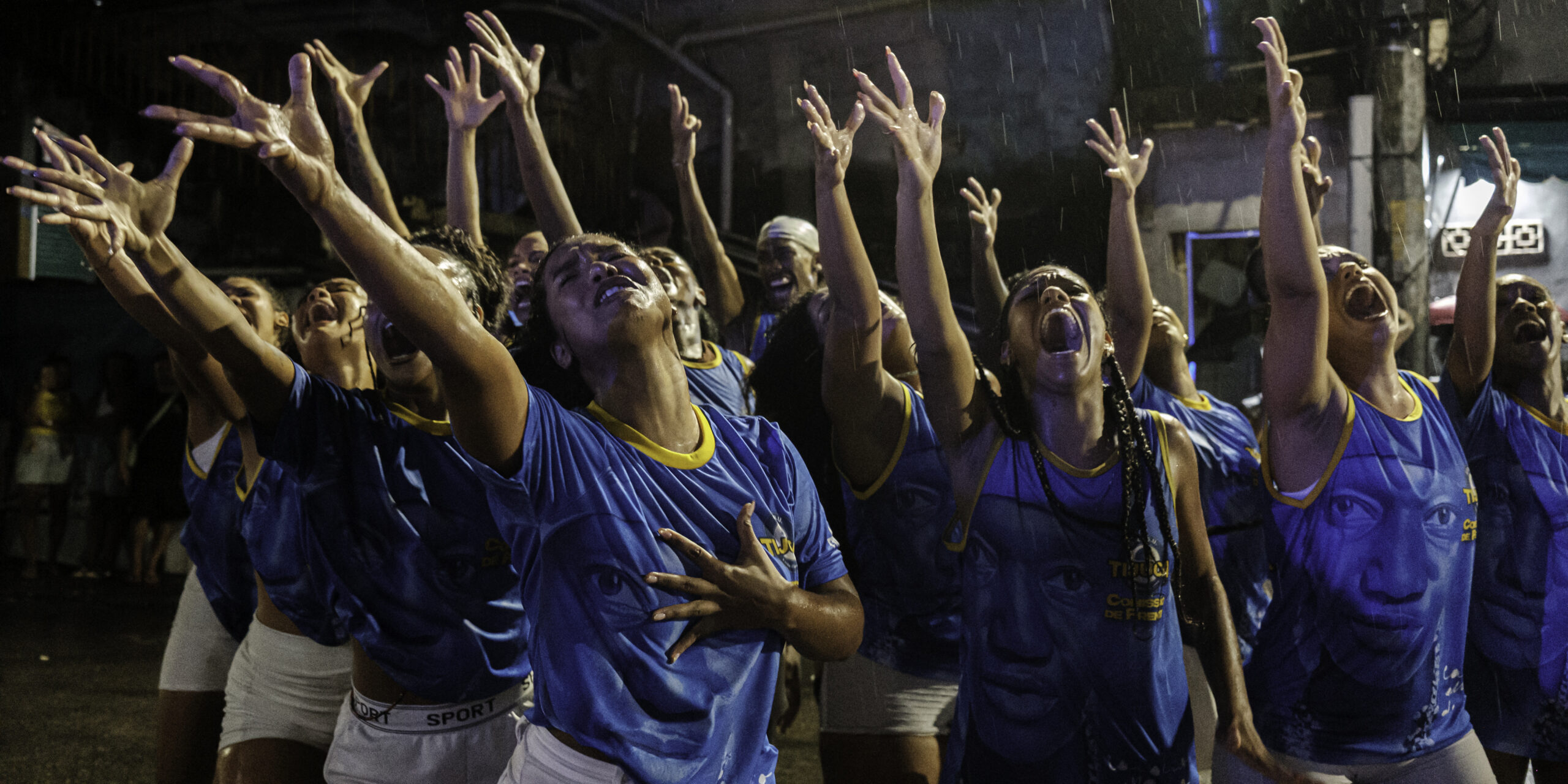 During a street rehearsal by the Unidos da Tijuca samba school, and under heavy rain, the opening performance group performs one of its choreographies from the storyline honoring writer Carolina Maria de Jesus near Favela do Borel, in the Tijuca neighborhood of Rio de Janeiro, Brazil.