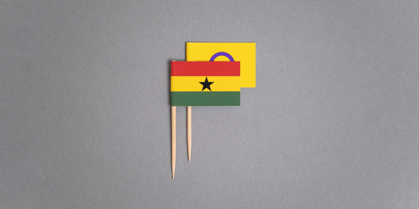 A photo illustration by Ricardo Tomás of Ghana's flag on a toothpick. It is covering the intersex flag (also on a toothpick), starting to rise behind it.