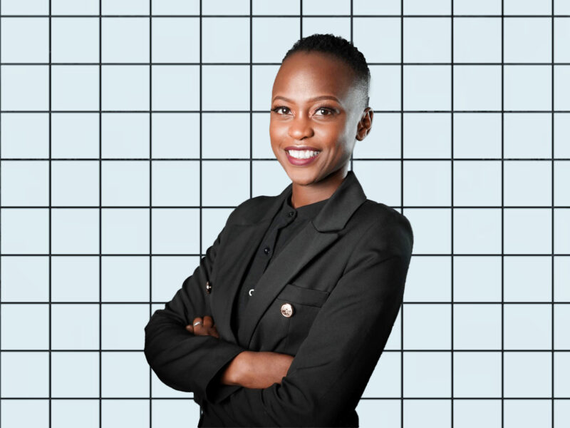 A portrait of Nerima Wako Ojiwa on a light blue grid background.