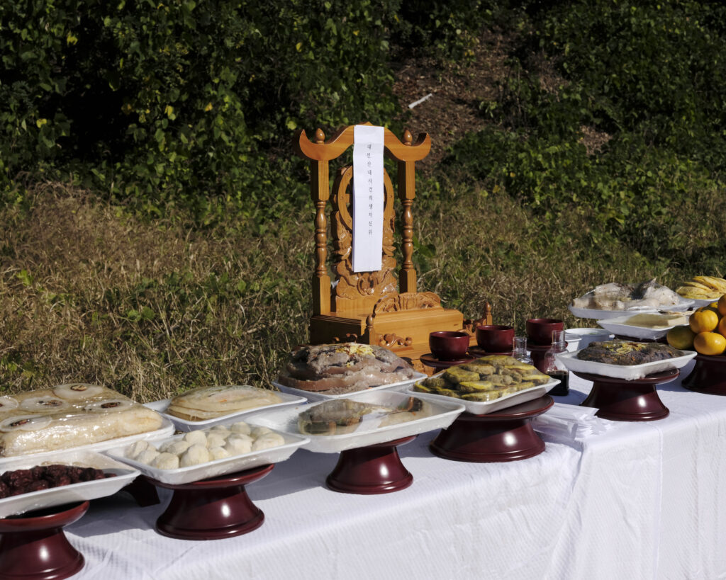 A photo of an ancestor table at Golryeonggol, piled with offerings.
