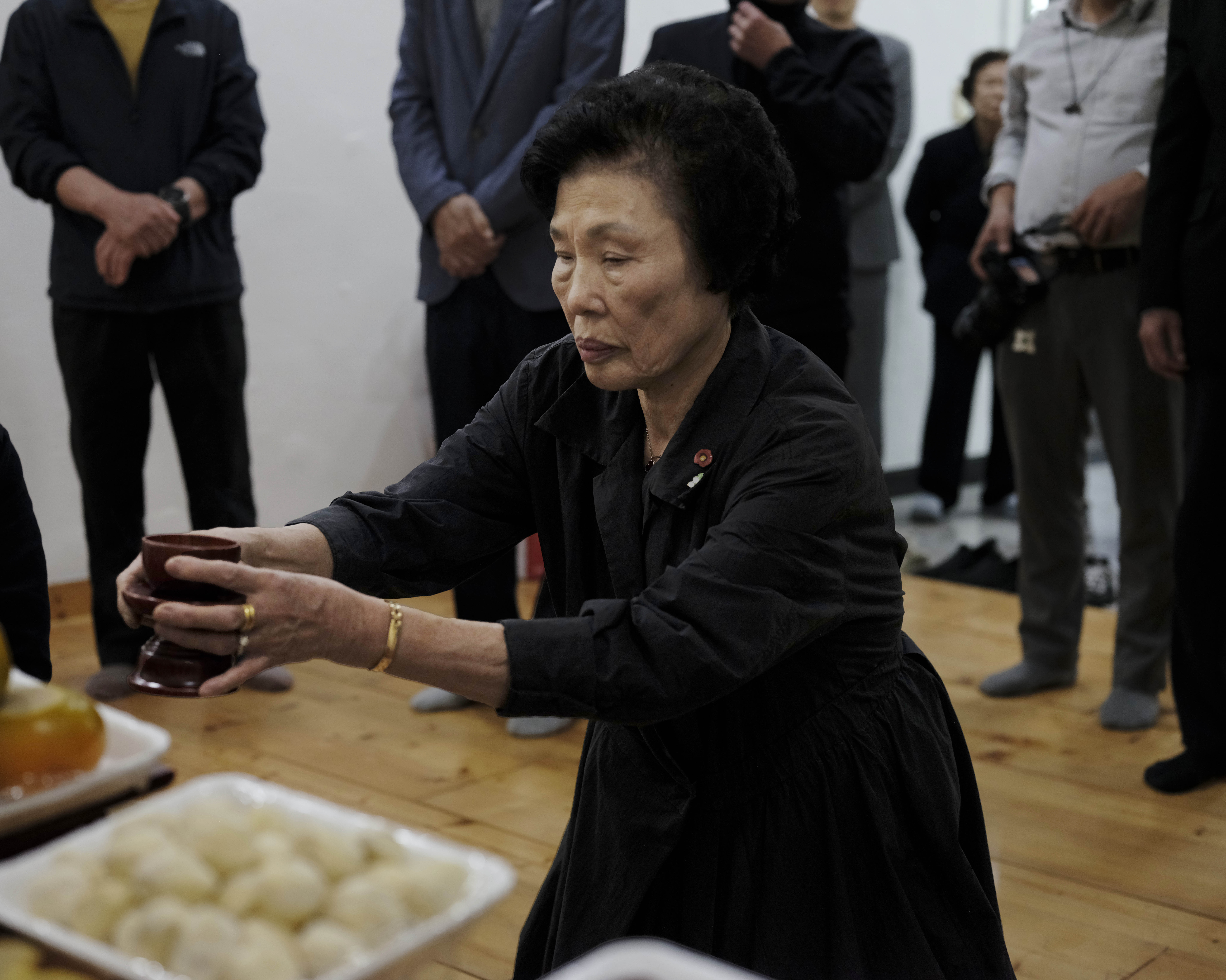 A photo of Chun Mi Kyung (Chun Imo) kneeling before an altar.