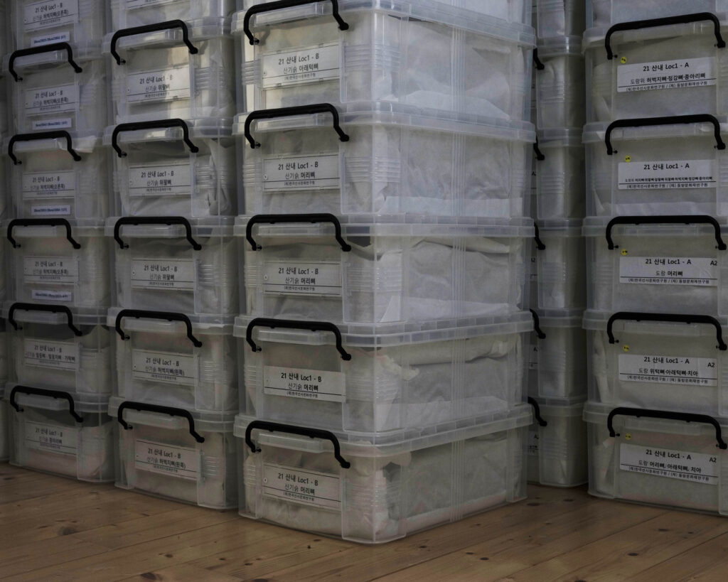 A photo of piles of storage boxes filled with exhumed remains at Sejong Memorial 
House.