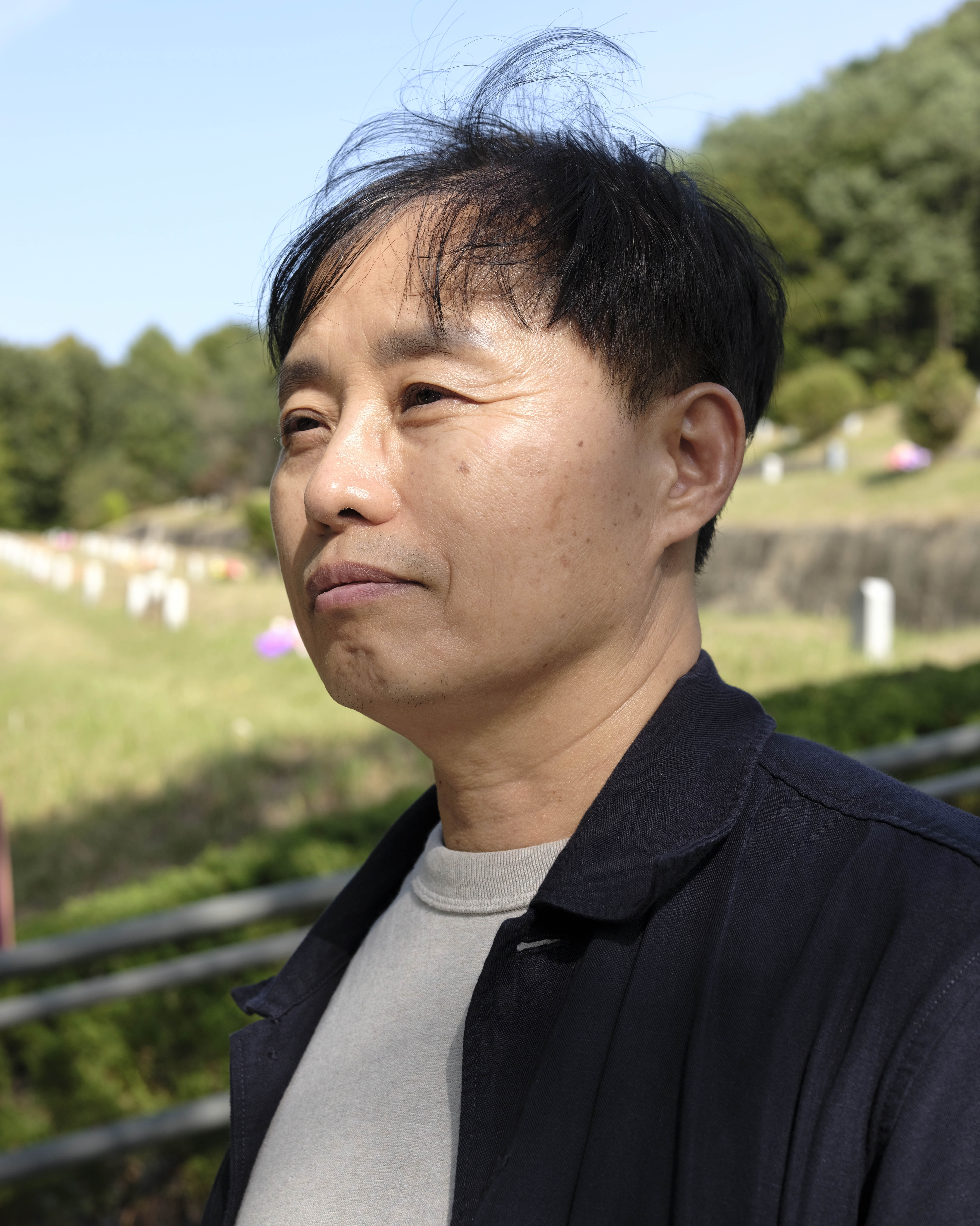 A portrait of Sim Kyu Sang standing outside.
